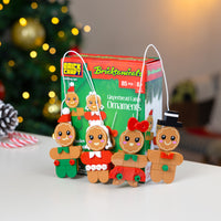 Bricktanicals Gingerbread Family Ornaments with packaging in front of a Christmas tree.