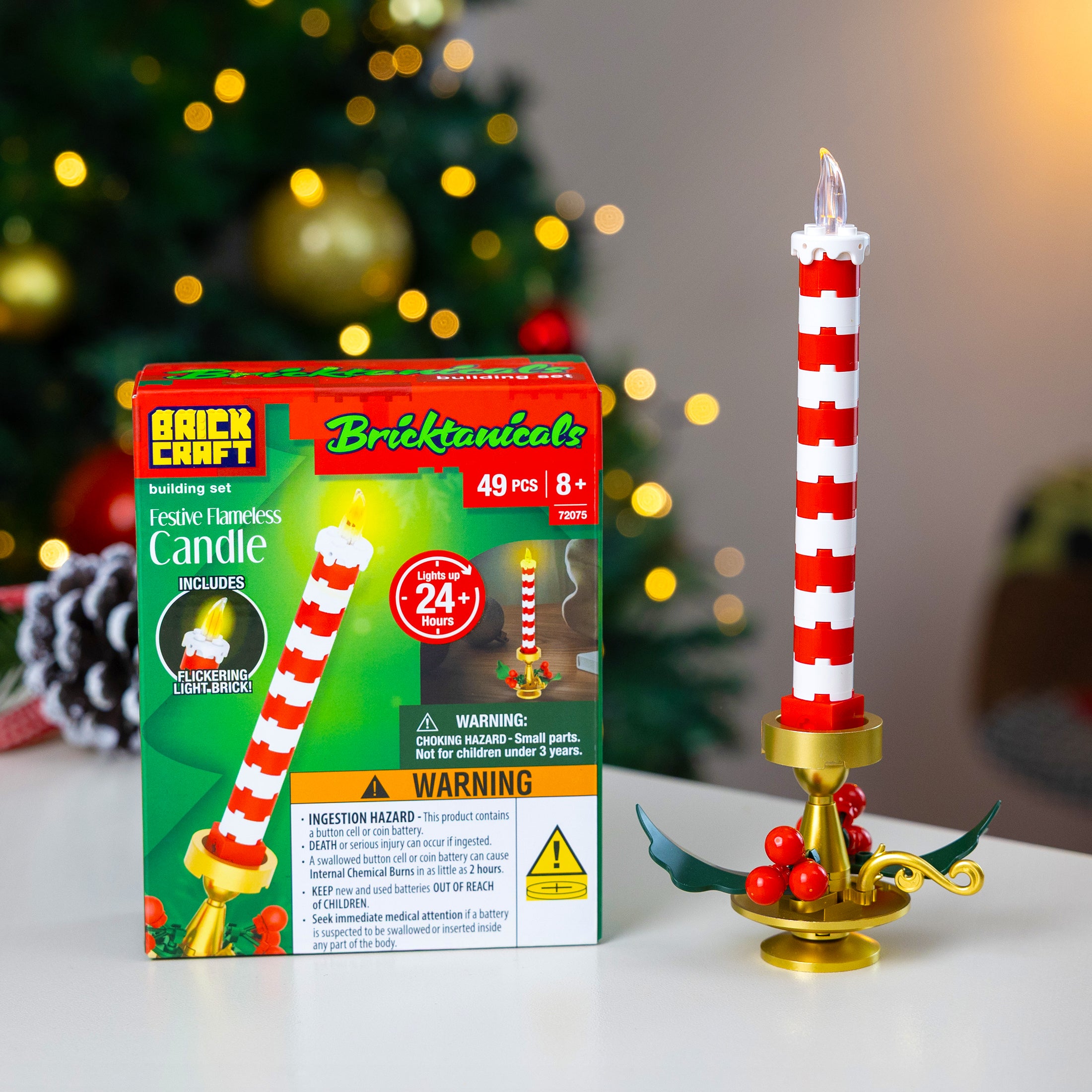 Brick Craft festive candle set with packaging in front of a Christmas tree.