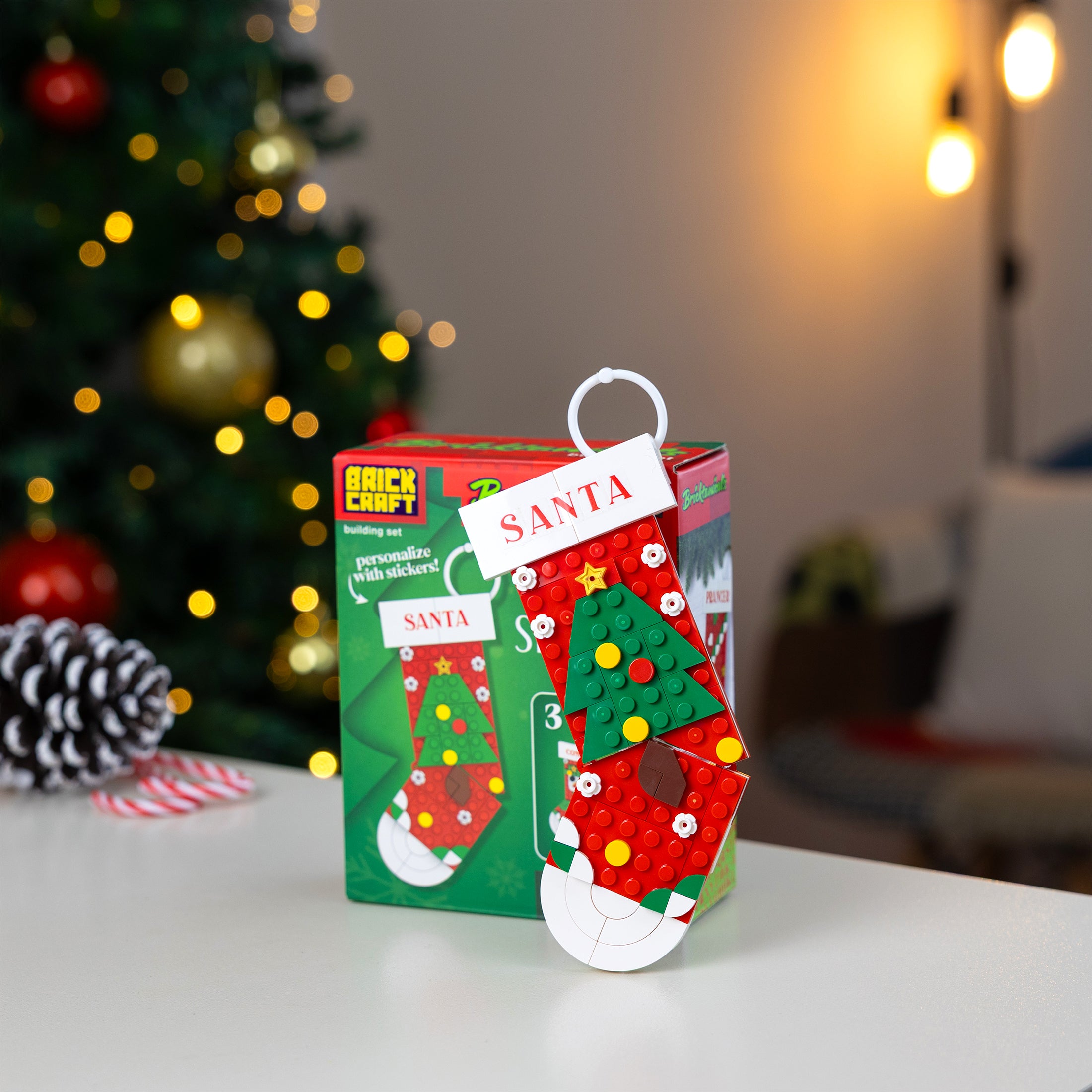 Christmas-themed craft kit with a decorative stocking on a table in front of a decorated tree.