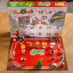 Advent calendar with 'The Grinch' theme featuring figurines and a countdown display.