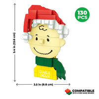 Toy figure of Charlie Brown with a red Santa hat and green scarf, showing dimensions and piece count on a white background.