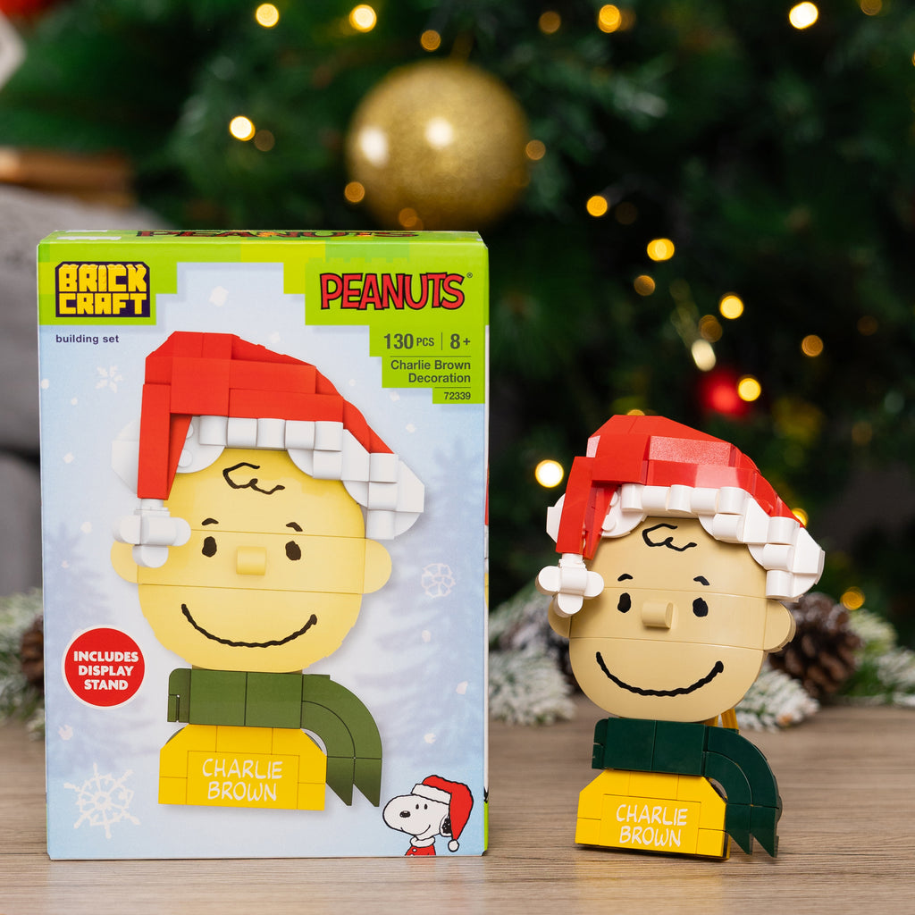 Christmas-themed building set with Charlie Brown figure and packaging in front of a decorated Christmas tree.
