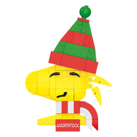 Toy figure of Woodstock from Peanuts with a green and red hat on a white background
