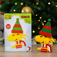 Brickcraft Peanuts building set with Woodstock figure and packaging against a festive background