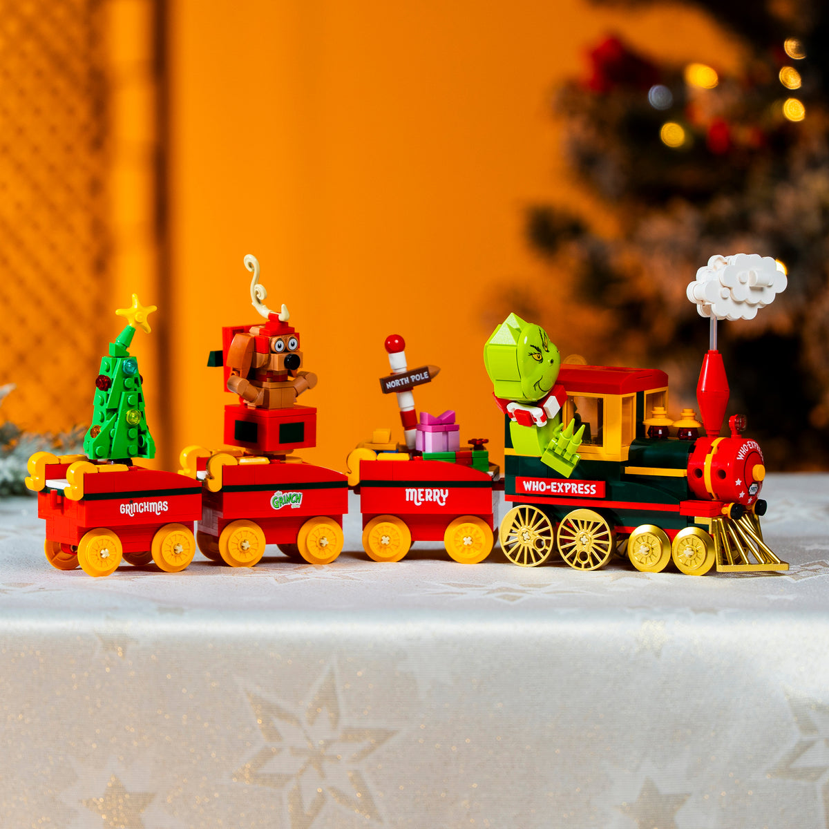 Toy train set with Christmas-themed decorations on a decorative surface.
