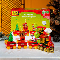 Toy train set with 'The Grinch' theme in front of its packaging