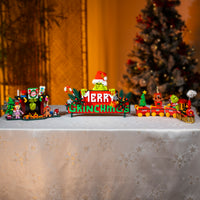 Christmas-themed toy set with a 'GRINCH' sign on a decorative surface.