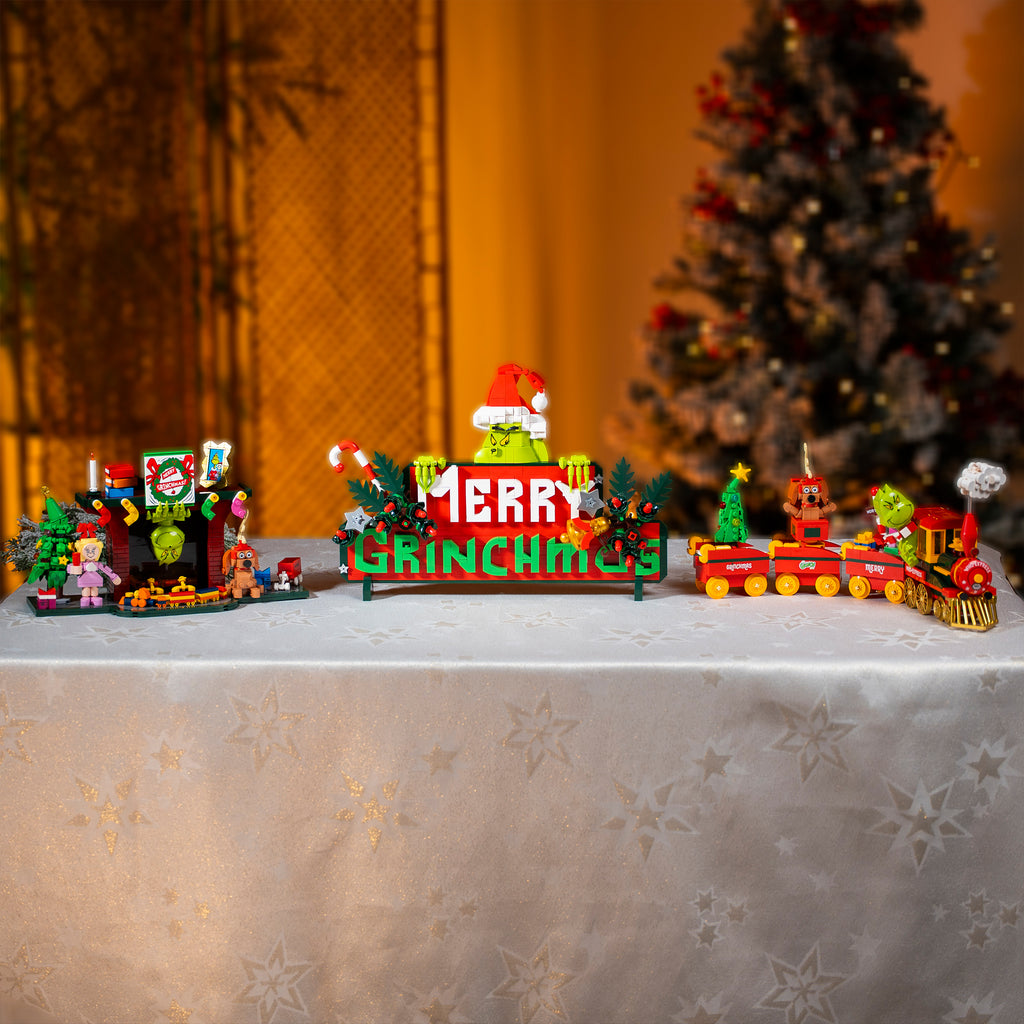 Christmas-themed toy set with a 'GRINCH' sign on a decorative surface.