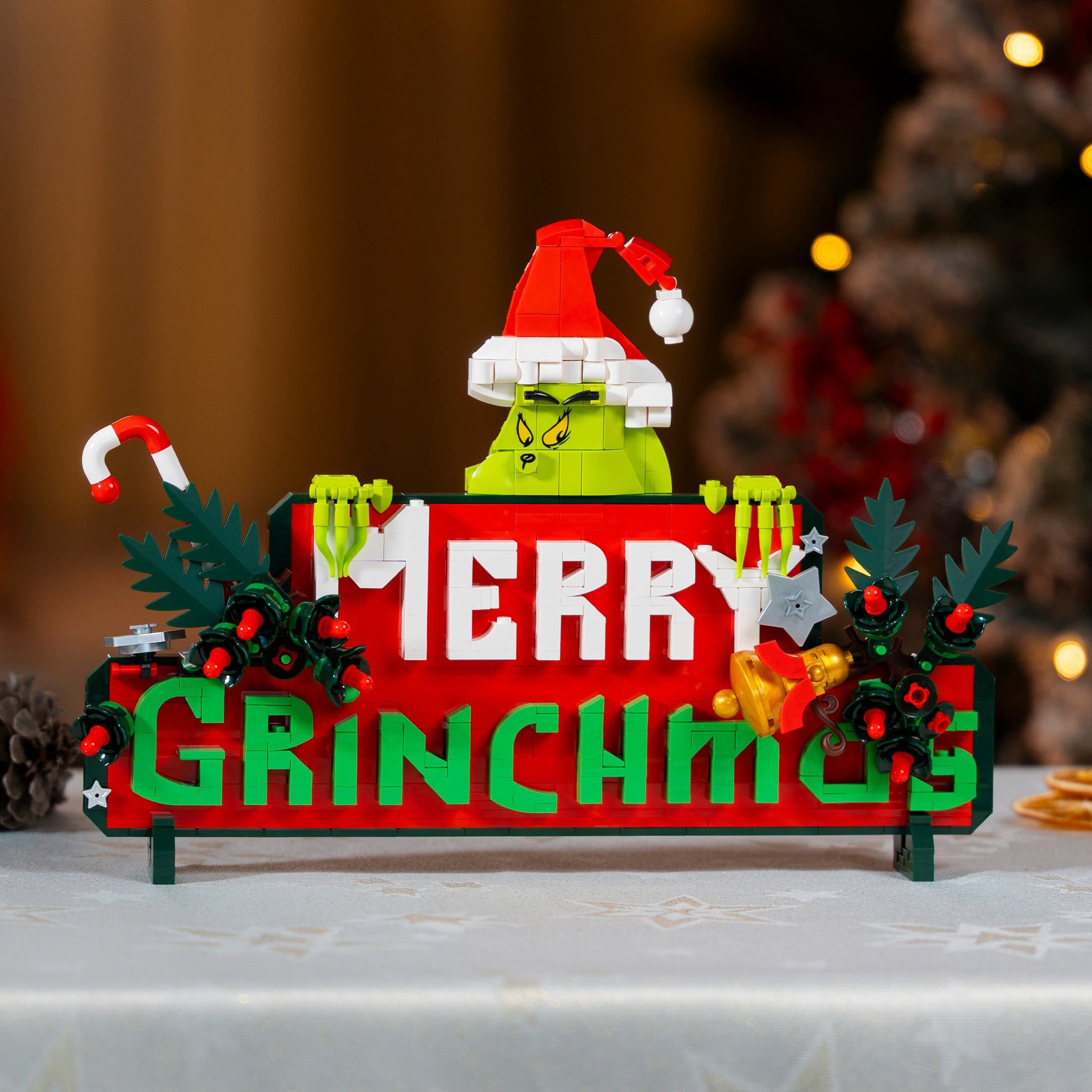 Decorative sign with Grinch-themed text and design on a blurred Christmas tree background