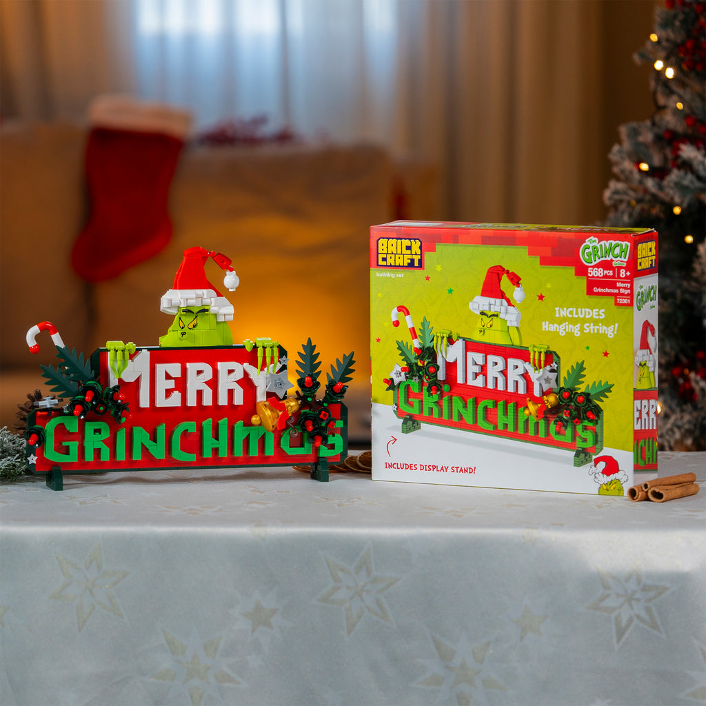 Grinch-themed Christmas display with decorative stand and packaging on a table.