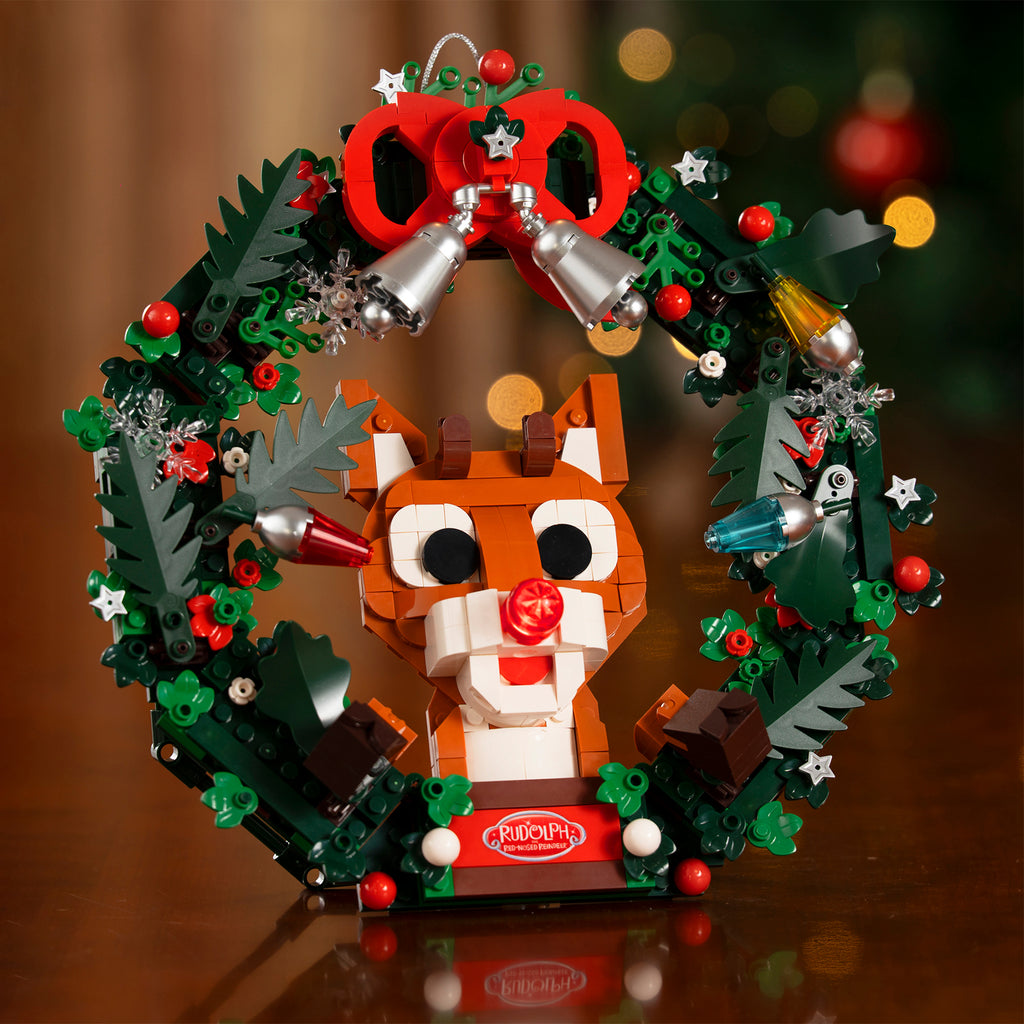 Christmas wreath withRudolph and festive decorations on a reflective surface.