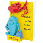 Toy book with red and blue fish figures on a yellow background, featuring Dr. Seuss text.