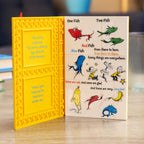 Children's book with colorful illustrations of fish and text on a wooden surface.