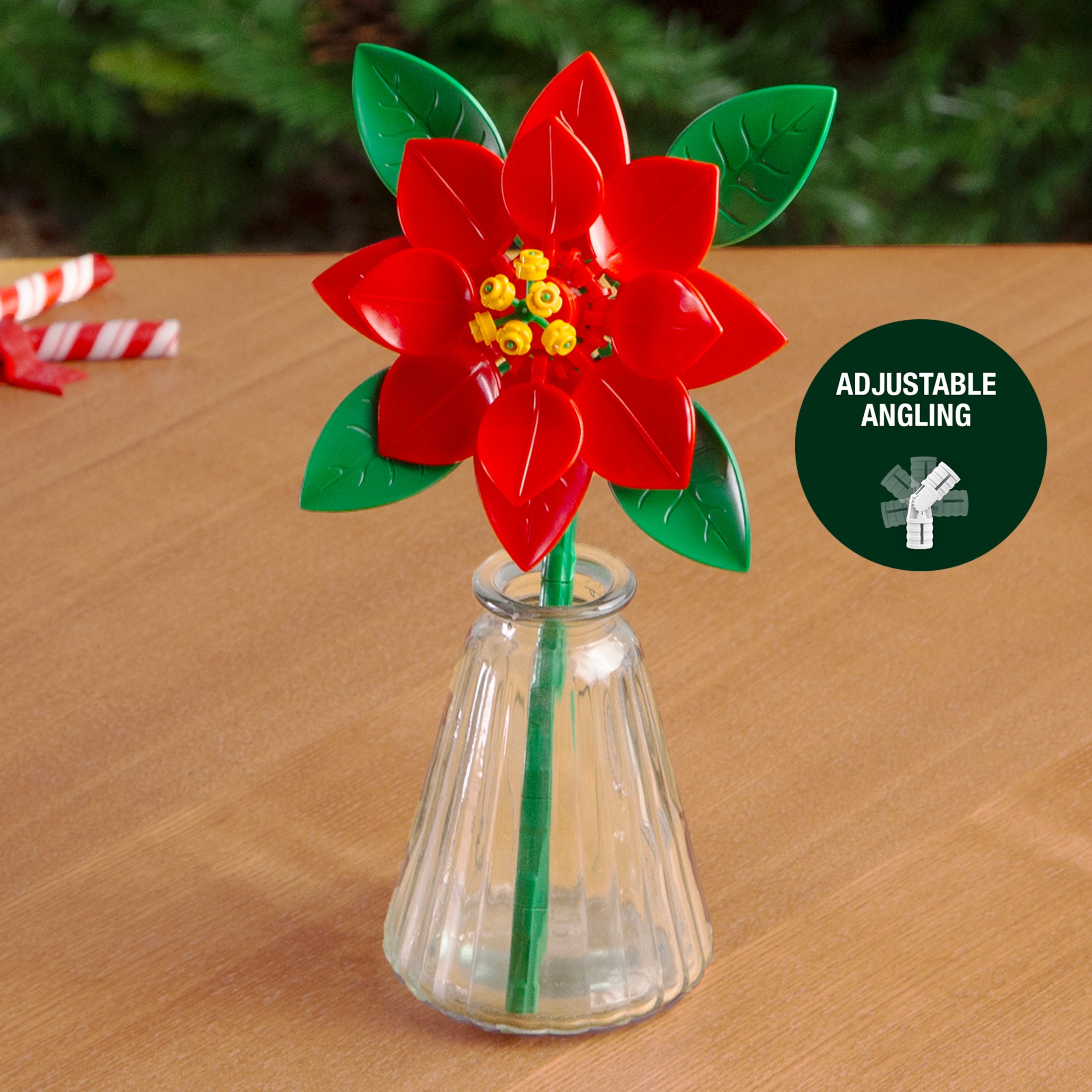 Red flower-shaped object with green leaves in a clear vase on a wooden surface, with 'Adjustable Angling' label.
