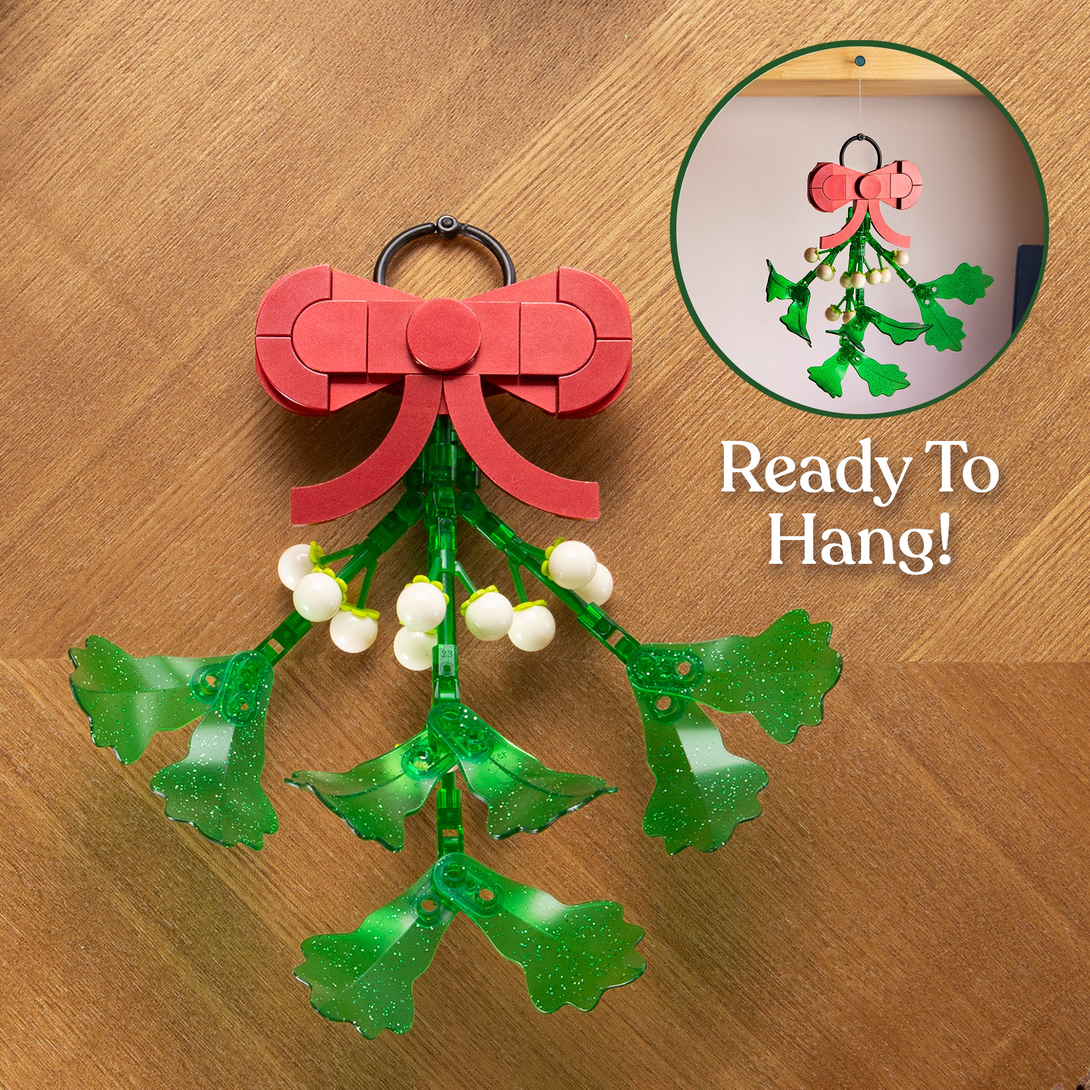 Decorative mistletoe with a red bow on a wooden surface, labeled 'Ready To Hang'.