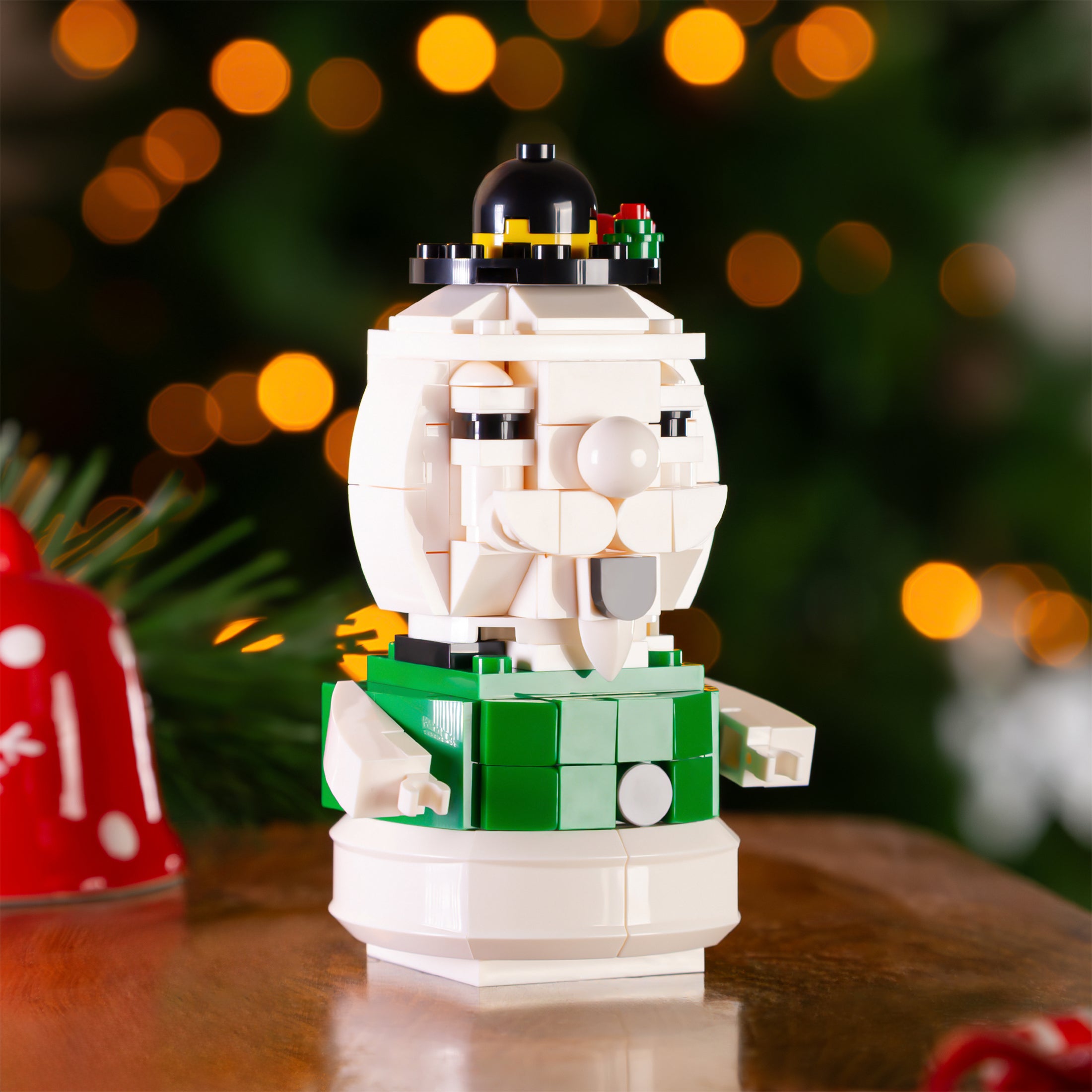 Brick snowman figure with a blurred Christmas tree background