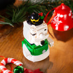 Toy snowman figure with festive decorations on a wooden surface